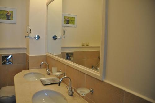 baño con lavabo y espejo grande en Thracian Cliffs Owners Apartments, en Kavarna