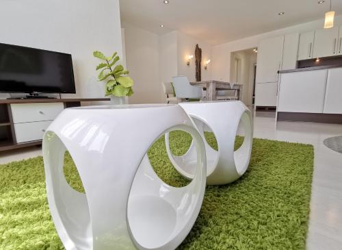 a white couch on a green rug in a living room at das Alpenblick & Outdoor Lodge Nauders in Nauders