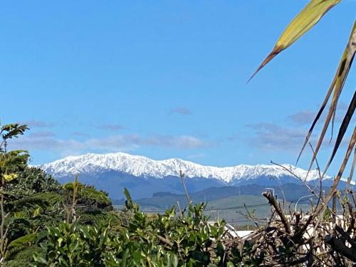a view of snow covered mountains in the distance at Otaki Beachfront Getaway in Otaki Beach