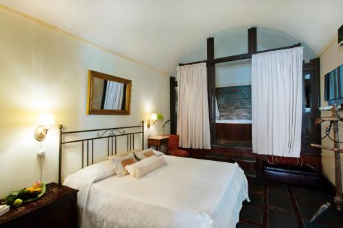 a bedroom with a white bed and a window at Relais Briuccia e Ristorante Capitolo Primo in Montallegro