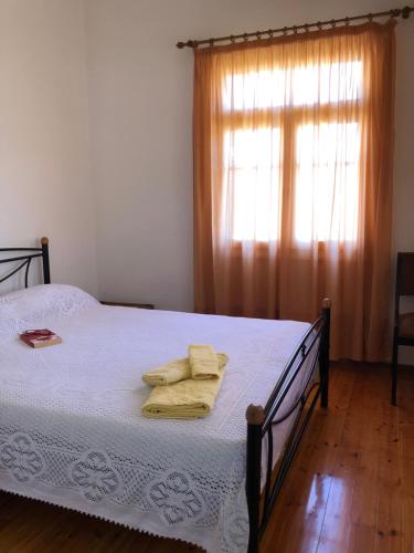 1 dormitorio con 1 cama con sábanas blancas y ventana en Martha IV, en Amaliás