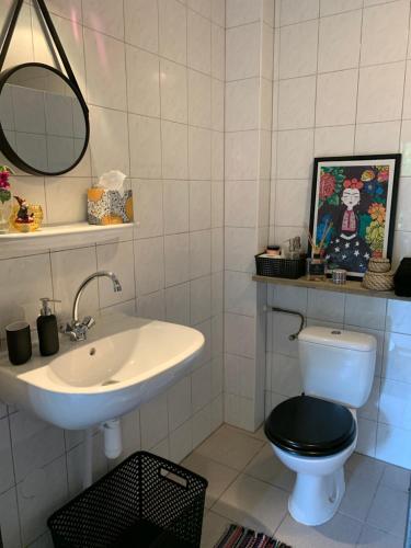 uma casa de banho com um lavatório, um WC e um espelho. em City Guesthouse em Hardenberg