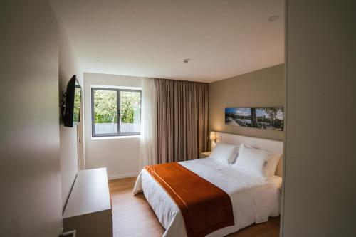 a hotel room with a bed and a window at Casa do Engenho Braga - Apartamentos com Vista Rio & SPA in Braga