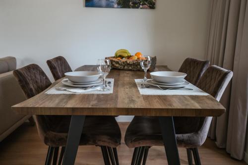 a wooden table with chairs and a bowl of fruit at Casa do Engenho Braga - Apartamentos com Vista Rio & SPA in Braga