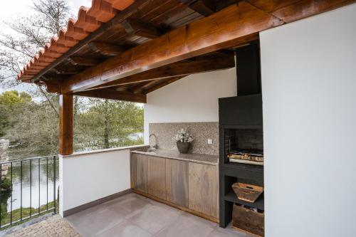 an outdoor kitchen with a fireplace on a balcony at Casa do Engenho Braga - Apartamentos com Vista Rio & SPA in Braga