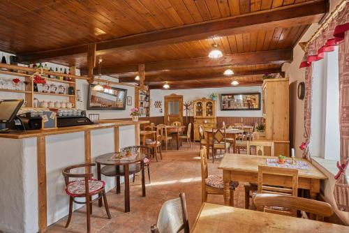 a restaurant with wooden ceilings and tables and chairs at POD SVATOU ANNOU - penzion a řízkovna in Horní Maršov