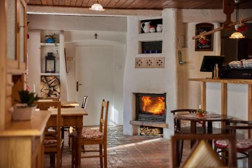 a living room with a fireplace and a table at POD SVATOU ANNOU - penzion a řízkovna in Horní Maršov