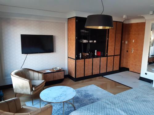 uma sala de estar com uma televisão, um sofá e uma mesa em KR47 Kossak Residence em Cracóvia