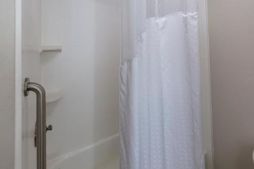 a shower with a white shower curtain in a bathroom at Holiday Inn Express Hotel & Suites Louisville South-Hillview, an IHG Hotel in Hillview