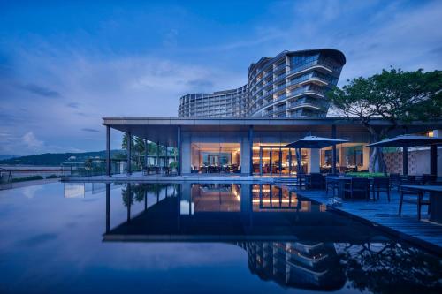 a house with a pool in front of a building at Intercontinental Shenzhen Dameisha Resort by IHG in Shenzhen