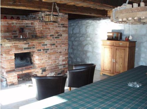 Cette chambre dispose d'une cheminée en briques, d'une table et de chaises. dans l'établissement Tuulingu Holiday House at Matsalu National Park, à Haeska