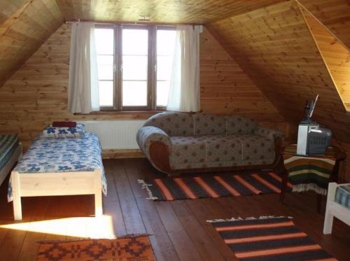 ein Wohnzimmer mit einem Sofa im Dachgeschoss in der Unterkunft Tuulingu Holiday House at Matsalu National Park in Haeska