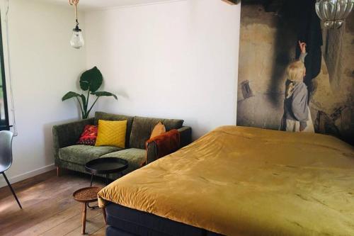 a bedroom with a large bed and a couch at Studio Mika met whirlpool! in Julianadorp