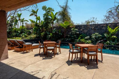 a patio with tables and chairs next to a pool at Casa de Agua in Tepoztlán
