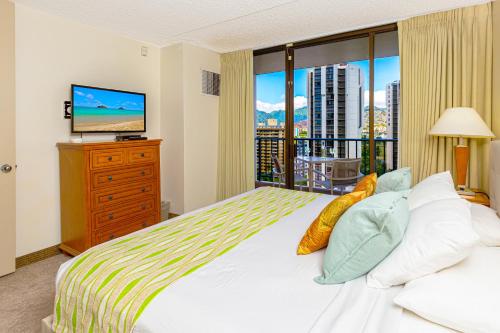 a bedroom with a bed and a large window at Mountain Views & Steps to Beach - Free Parking! in Honolulu