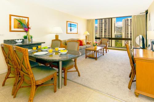 a living room with a table and chairs and a couch at Mountain Views & Steps to Beach - Free Parking! in Honolulu