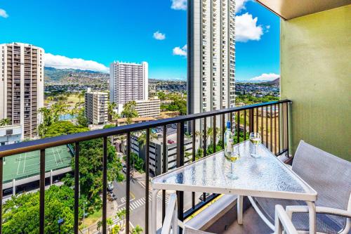 a balcony with a table with wine glasses on it at Mountain Views & Steps to Beach - Free Parking! in Honolulu