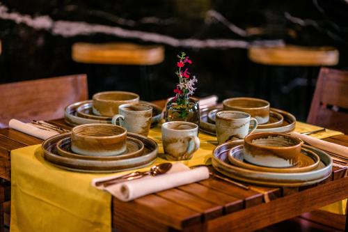 a table with plates and cups on a yellow table cloth at Casa de Agua in Tepoztlán