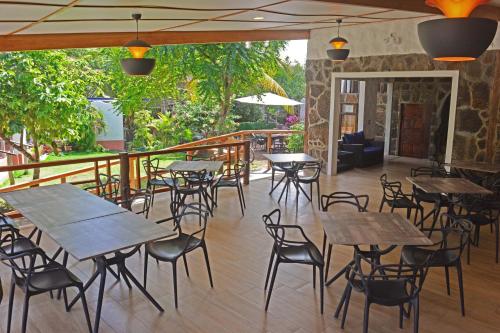 a restaurant with tables and chairs on a deck at Lava House Hostal in Puerto Ayora