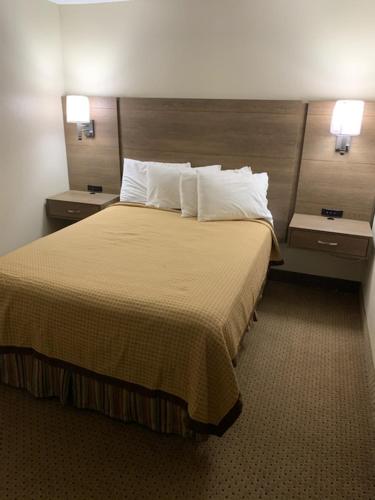 a hotel room with a large bed with two night stands at Riverside Motor Lodge - Pigeon Forge in Pigeon Forge