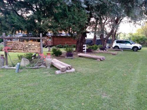 a yard with logs in the grass with a white car at Pualy Resort & Spa in Belén de Escobar