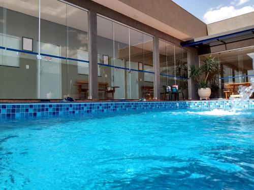 a swimming pool with a fountain in a building at Casa Família Porto in Olímpia