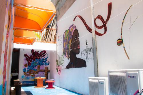 a wall with a painting of a woman on it at A Casa dos Mestres in Salvador