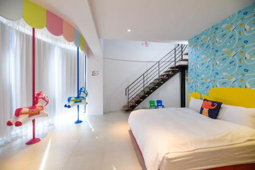 ein Schlafzimmer mit einem großen Bett und einem Spielbereich in der Unterkunft 澎湖遛一遛旅店 in Magong