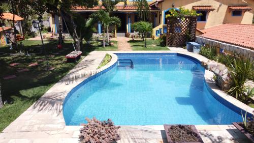 a swimming pool in a yard next to a house at Casa Litoral Sul - Praia Bela/ PB in Pitimbu