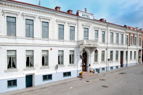 a white building with a sign on top of it at Laholms Stadshotell in Laholm