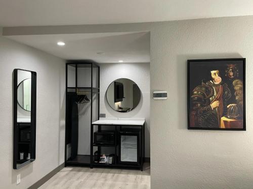 a bathroom with a mirror and a painting on the wall at Rodeway Inn St Augustine Historic District in Saint Augustine