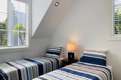 A bed or beds in a room at Settler's Cottage - Russell Cottages Collection