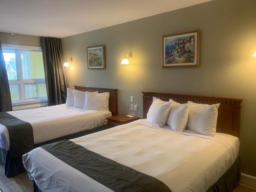 A bed or beds in a room at Hotel and Suites Les Laurentides