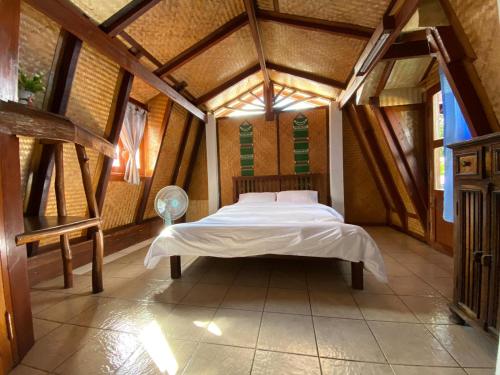 ein Schlafzimmer mit einem Bett in einem Zimmer mit Holzdecken in der Unterkunft No. 8 Pai in Pai