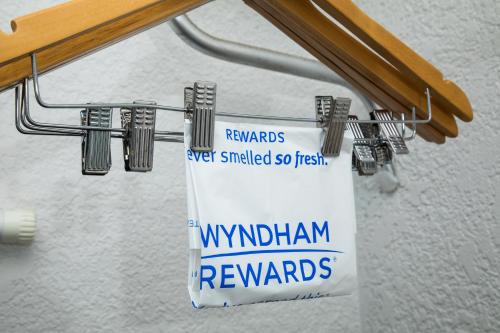 a sign hanging from a metal rack in a room at Days Inn by Wyndham Stuart in Stuart