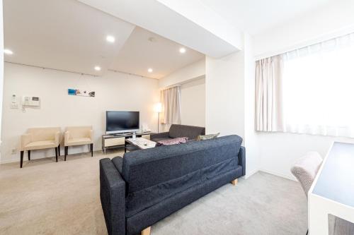 a living room with a couch and a tv at Pangoo Shinagawa in Tokyo