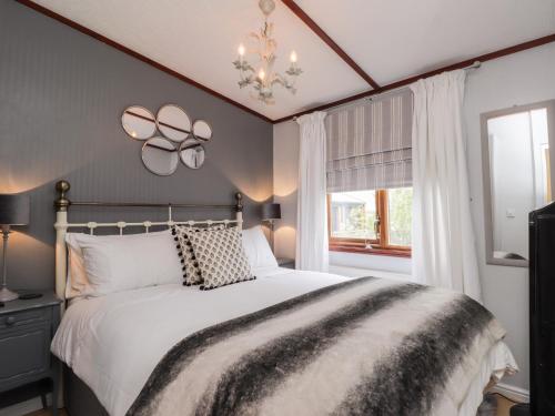 a bedroom with a large white bed and a window at 4 Country View Park in Faversham