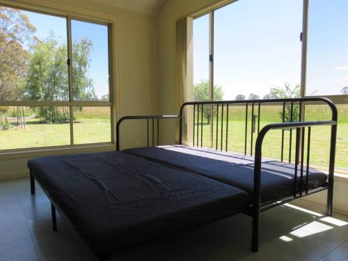 a bed in a room with a large window at Wombat Forest Country Retreat in Trentham East