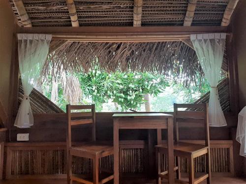 PUQIO ECOLODGE في تارابوتو: كرسيين وطاولة في غرفة مع نافذة