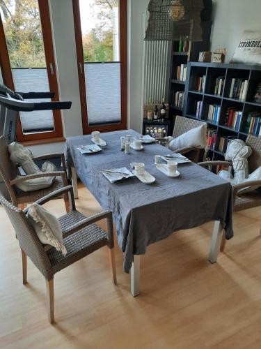 Suite ! Moin Die Rattanbude في فونستورف: طاولة مع قماش الطاولة الزرقاء وكرسيين