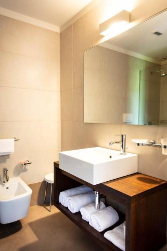 a bathroom with a white sink and a mirror at Sweet Hotel in Longa