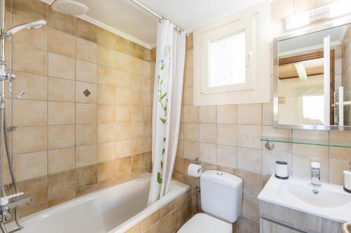 une salle de bain avec toilettes, baignoire et lavabo dans l'établissement Petrinos Cottage, à Dafnila