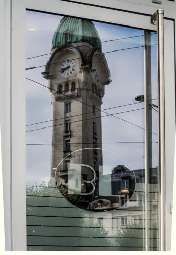 a reflection of a clock tower in a window at Hôtel de la Poste in Limoges