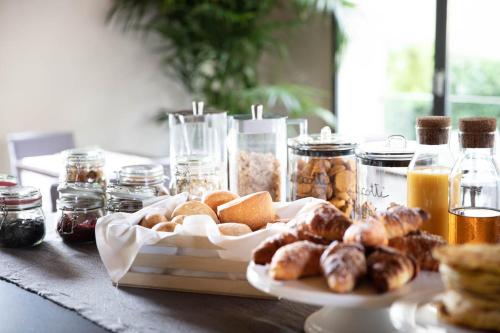 a table with a plate of pastries and jars of food at Sweet Hotel in Longa