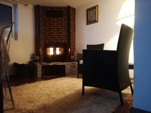 a living room with a fireplace and a chair at Vila Perla Govorei in Băile Govora