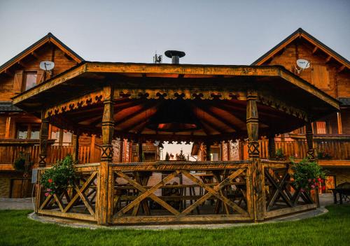 a large wooden pavilion in front of a house at Cabana Panoramic VIP Baile Figa in Beclean