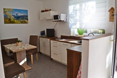 a kitchen with a table and a table and a kitchen with a tableablish at Ferienwohnung Heimberger - Appartement 2 in Sölling