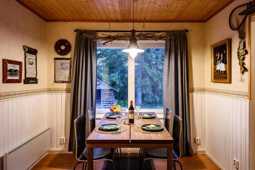 a dining room with a table and a large window at Taikaloora-lomahuoneisto Oulujärvi in Vaala