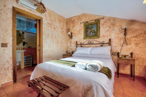 sypialnia z dużym łóżkiem i drewnianą ławką w obiekcie Casa Rural La Torca Ruidera w mieście Ruidera