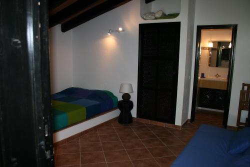 1 dormitorio con 1 cama y 1 habitación con espejo en Villa Pedras del Rey, en Luz de Tavira